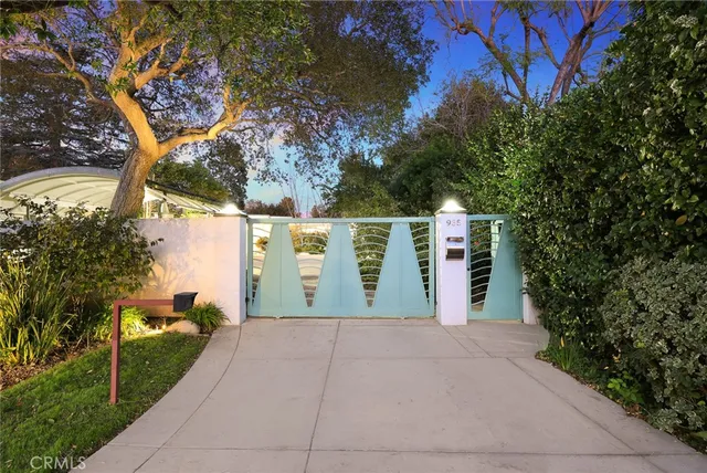 a front view of a house with a yard and trees