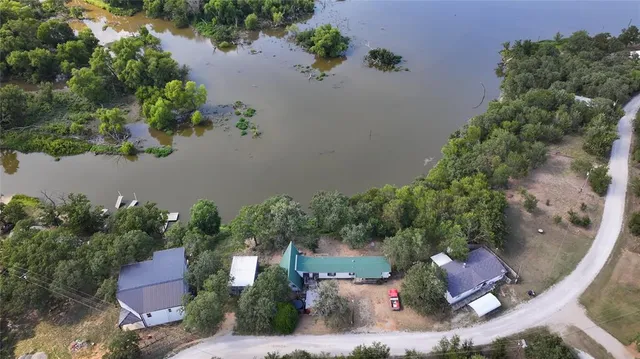 an aerial view of a house with a yard and lake view