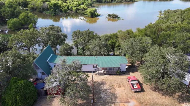 an aerial view of a house with a yard and lake view