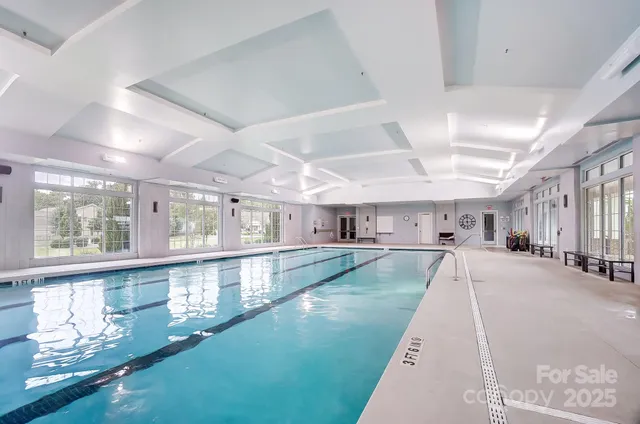 a large white kitchen with lots of counter space a sink and view living room