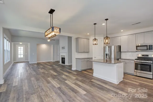 a view of kitchen with refrigerator microwave and stove