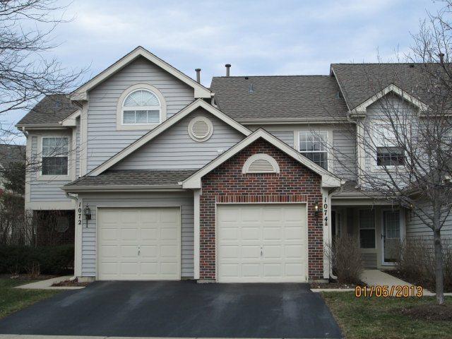 1074 Stillwater Road Elgin, IL 60120 - Photo 1 of 11 a front view of a house with a yard and garage