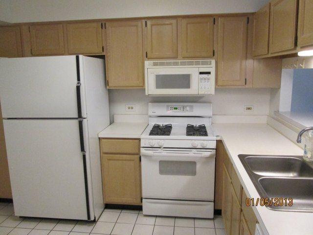 1074 Stillwater Road Elgin, IL 60120 - Photo 2 of 11 a kitchen with a refrigerator sink stove and cabinets