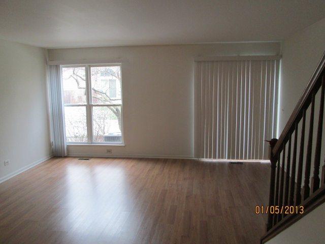 1074 Stillwater Road Elgin, IL 60120 - Photo 5 of 11 an empty room with wooden floor and windows