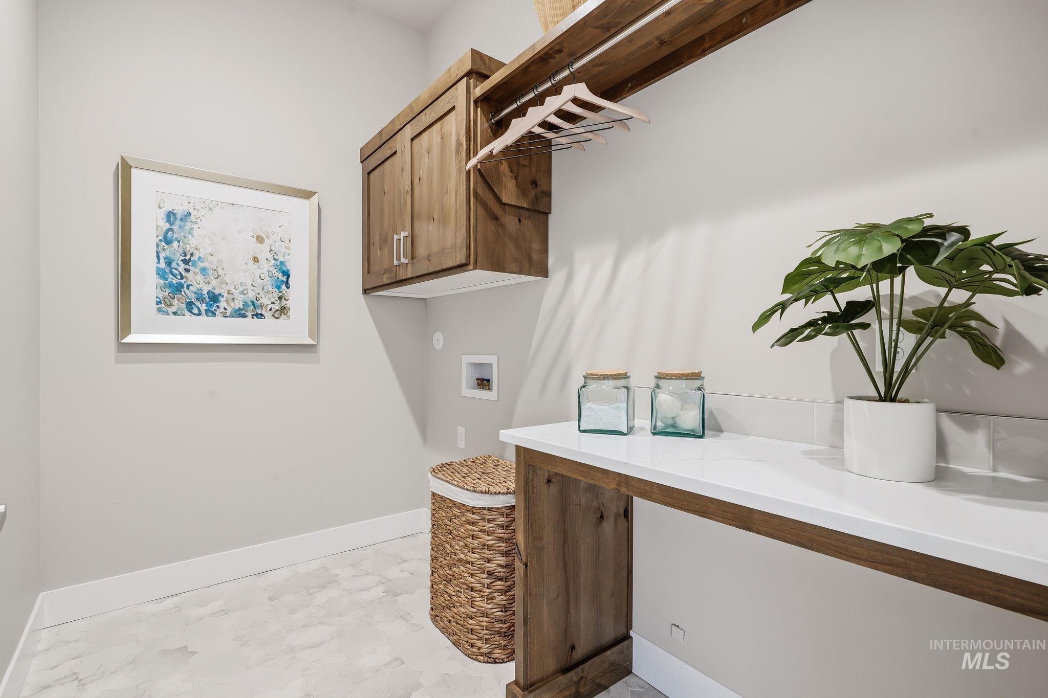 470 South Radiator Way Boise, ID 83716 - Photo 48 of 50 Laundry room featuring wood-finish cabinetry, a white countertop, and a clothes hanging rod