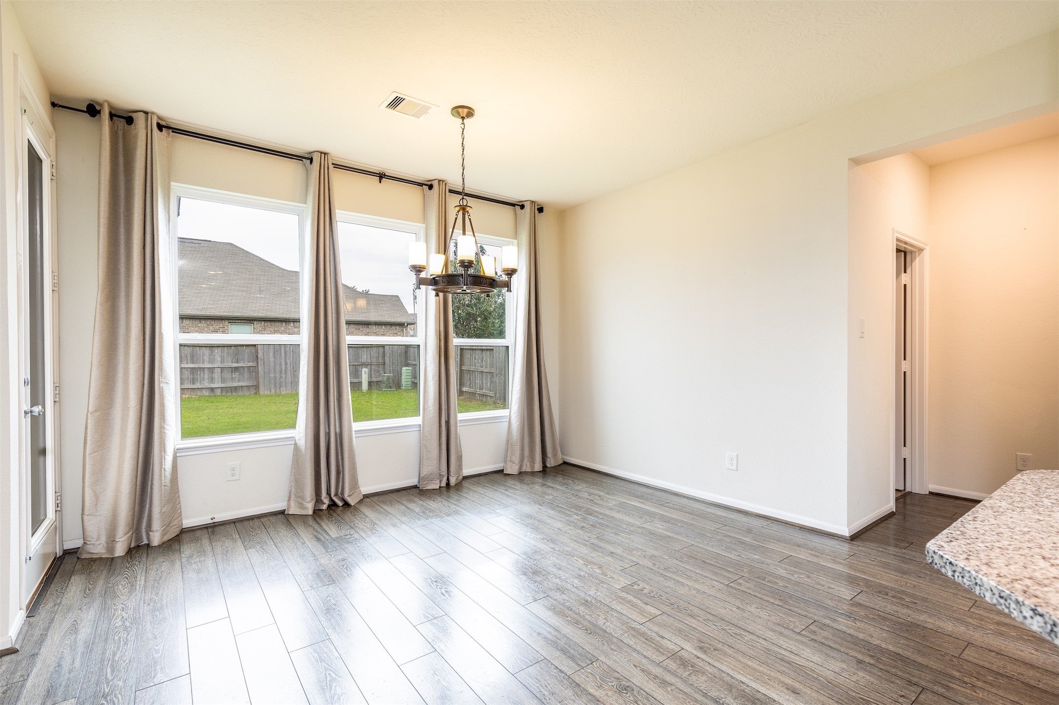15623 Hanover Breeze Lane Houston, TX 77044 - Photo 12 of 46 a view of an empty room with wooden floor and a window