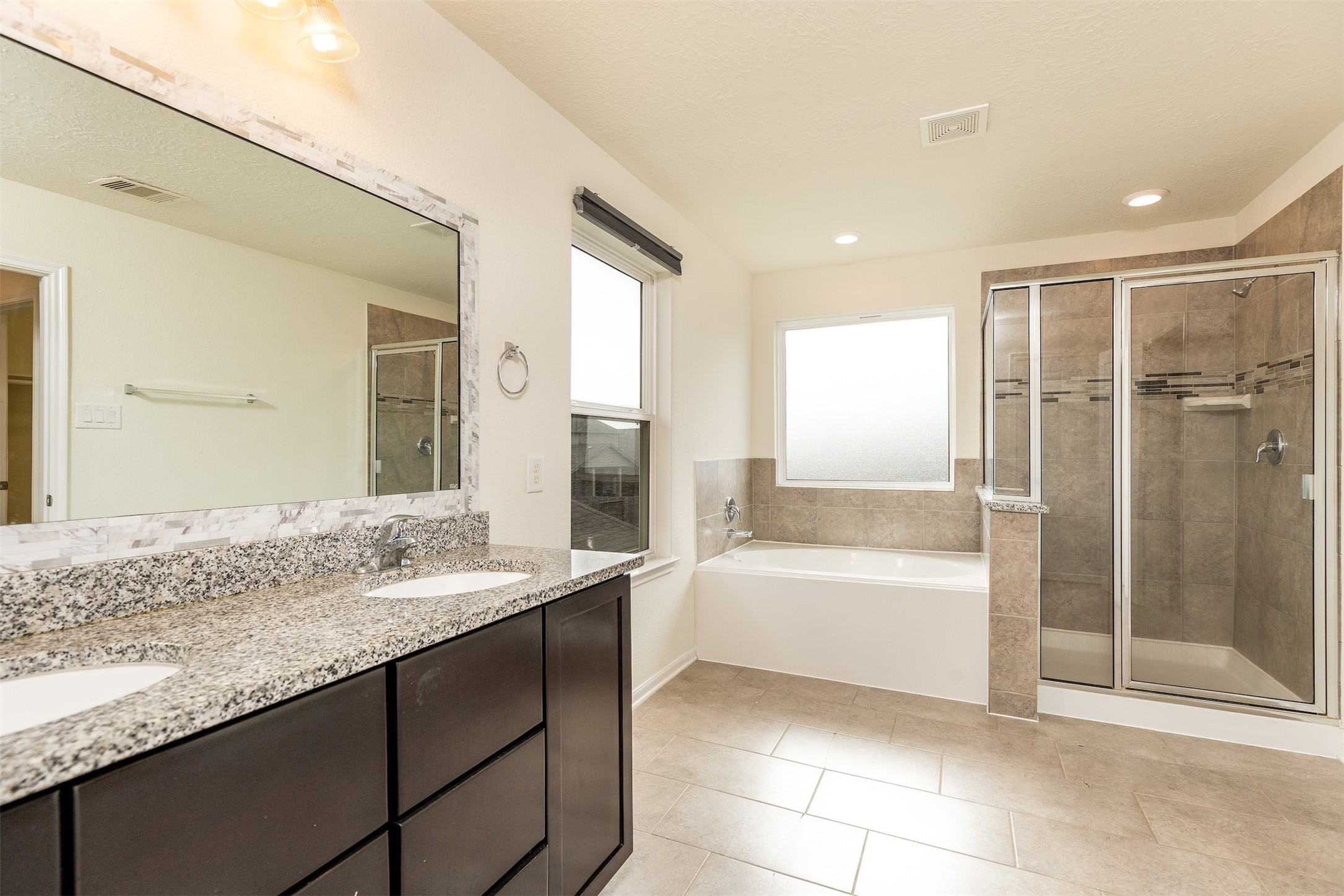 15623 Hanover Breeze Lane Houston, TX 77044 - Photo 17 of 46 a bathroom with a granite countertop sink a mirror and a bathtub