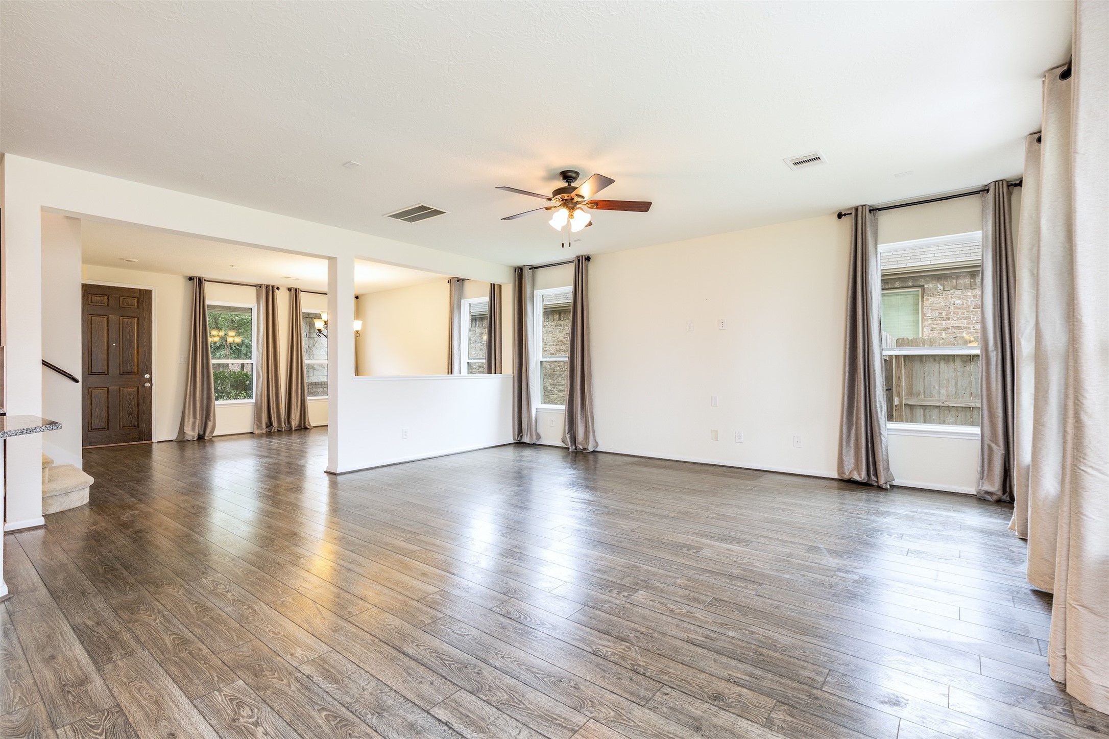 15623 Hanover Breeze Lane Houston, TX 77044 - Photo 6 of 46 a view of an empty room with a window and wooden floor