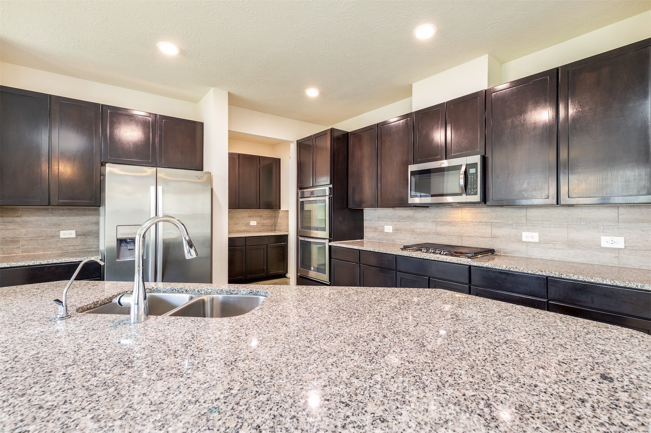 15623 Hanover Breeze Lane Houston, TX 77044 - Photo 10 of 46 a large kitchen with granite countertop a large counter top stainless steel appliances and cabinets