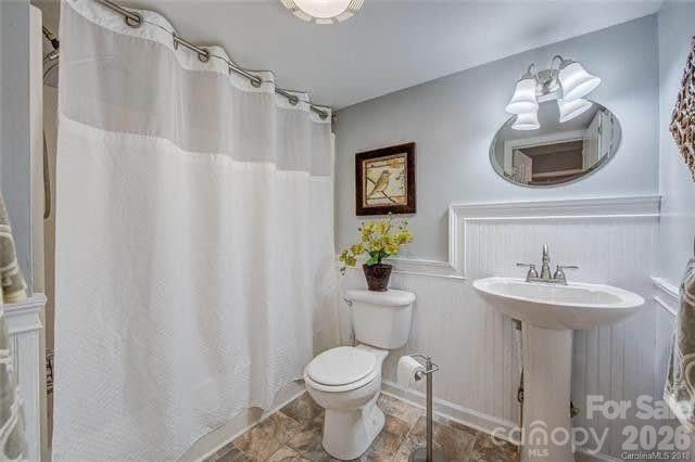 116 7th Street Cramerton, NC 28032 - Photo 8 of 9 a bathroom with a toilet sink and mirror