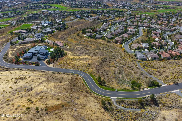 an aerial view of a house with a yard and lake view in back