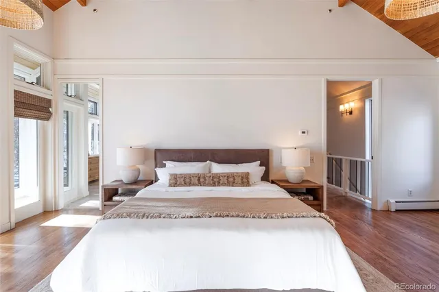 a spacious bedroom with a bed and wooden floor