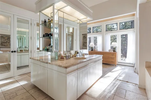 a bathroom with a granite countertop sink and a large mirror