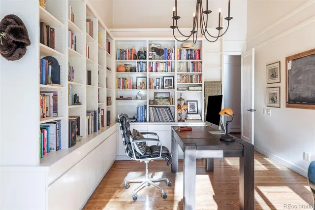 a workspace with furniture a bookshelf and a window