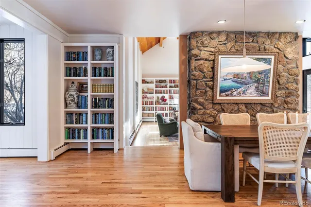 a living room with couches and a dining table with wooden floor