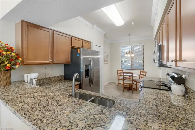 a kitchen with granite countertop a sink stove and refrigerator