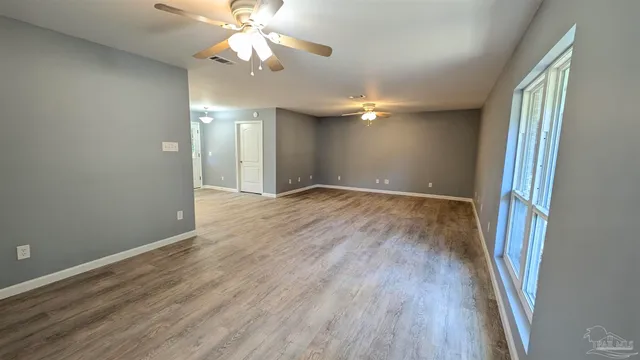 wooden floor in an empty room with a window