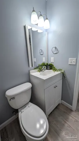 a bathroom with a granite countertop toilet sink and mirror
