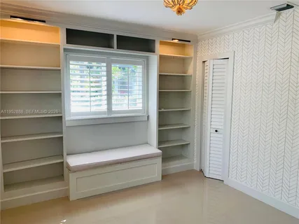 a view of walk in closet with empty racks