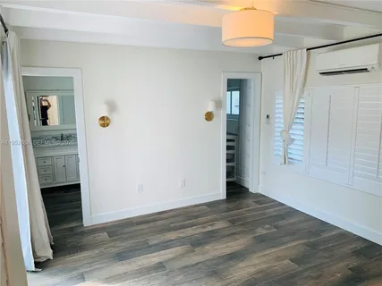 a view of an empty room with wooden floor and a fireplace