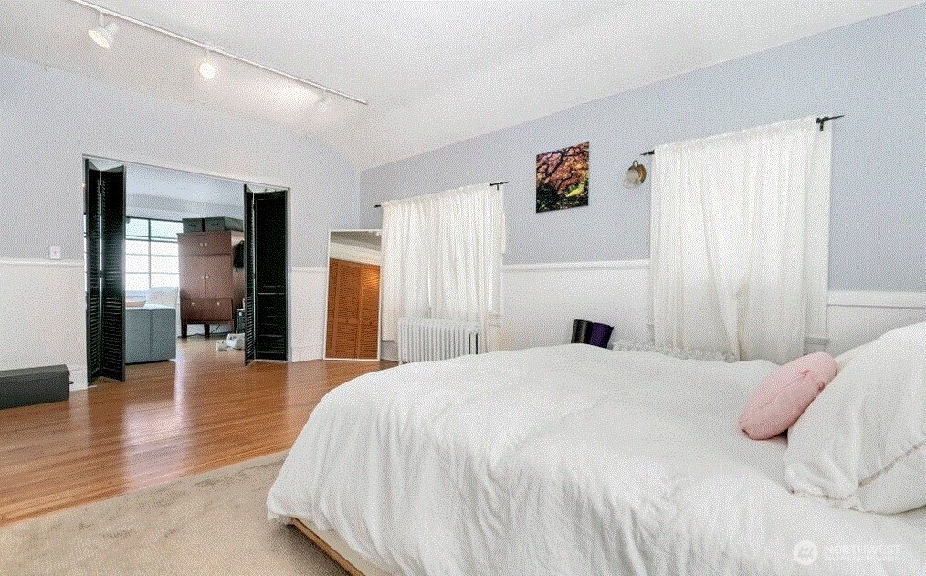 1745 12th Avenue South, Unit 1 4 Seattle, WA 98144 - Photo 26 of 39 a spacious bedroom with a bed and a large mirror