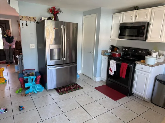 a kitchen with stainless steel appliances kitchen island granite countertop a refrigerator and a stove top oven