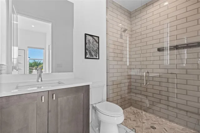 a bathroom with a granite countertop toilet sink and mirror