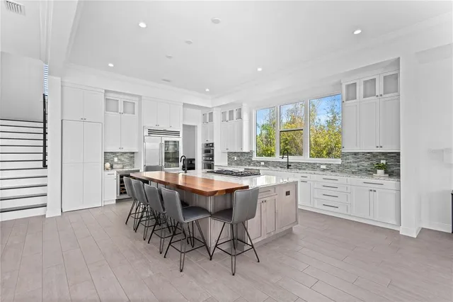 a large kitchen with kitchen island a sink table and chairs