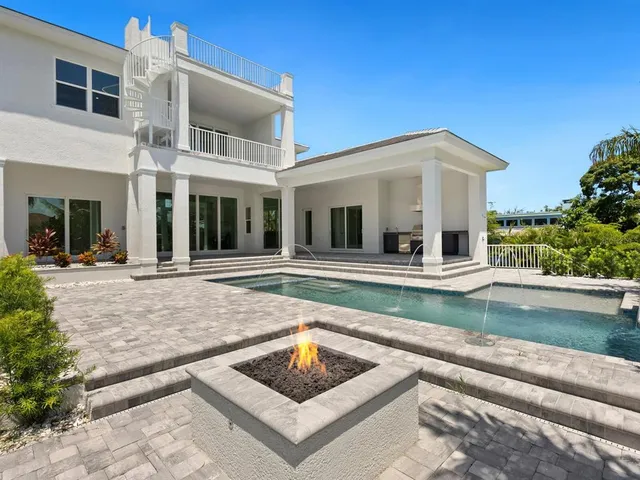 a view of a white house with a swimming pool and a yard