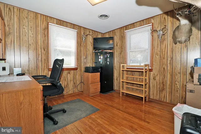 a view of a workspace with furniture and a window