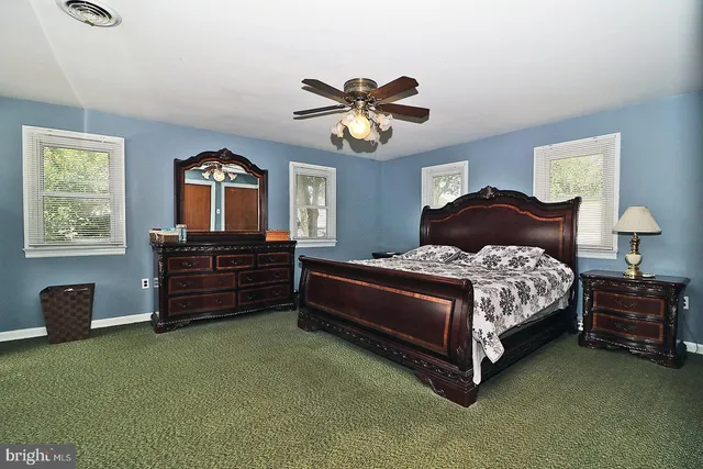 a bedroom with a bed dresser and a window