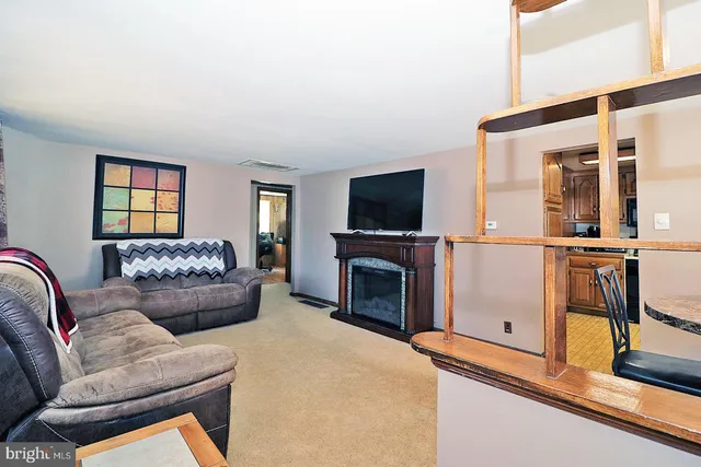 a living room with furniture a flat screen tv and a fireplace