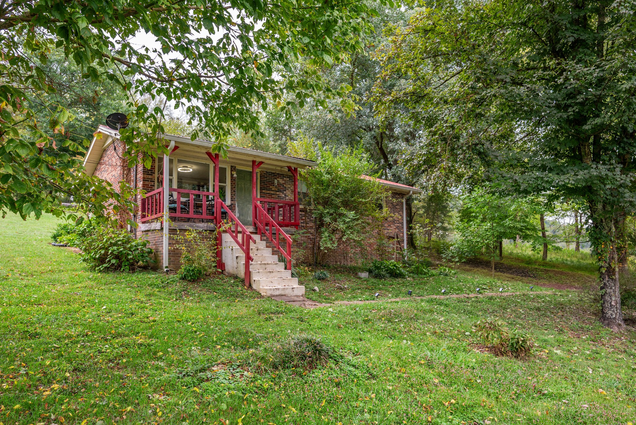 a view of a backyard with a barn and large trees