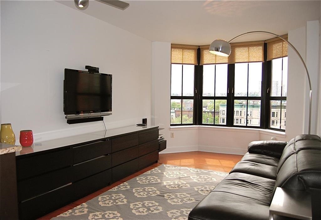 a living room with a large window and a flat screen tv