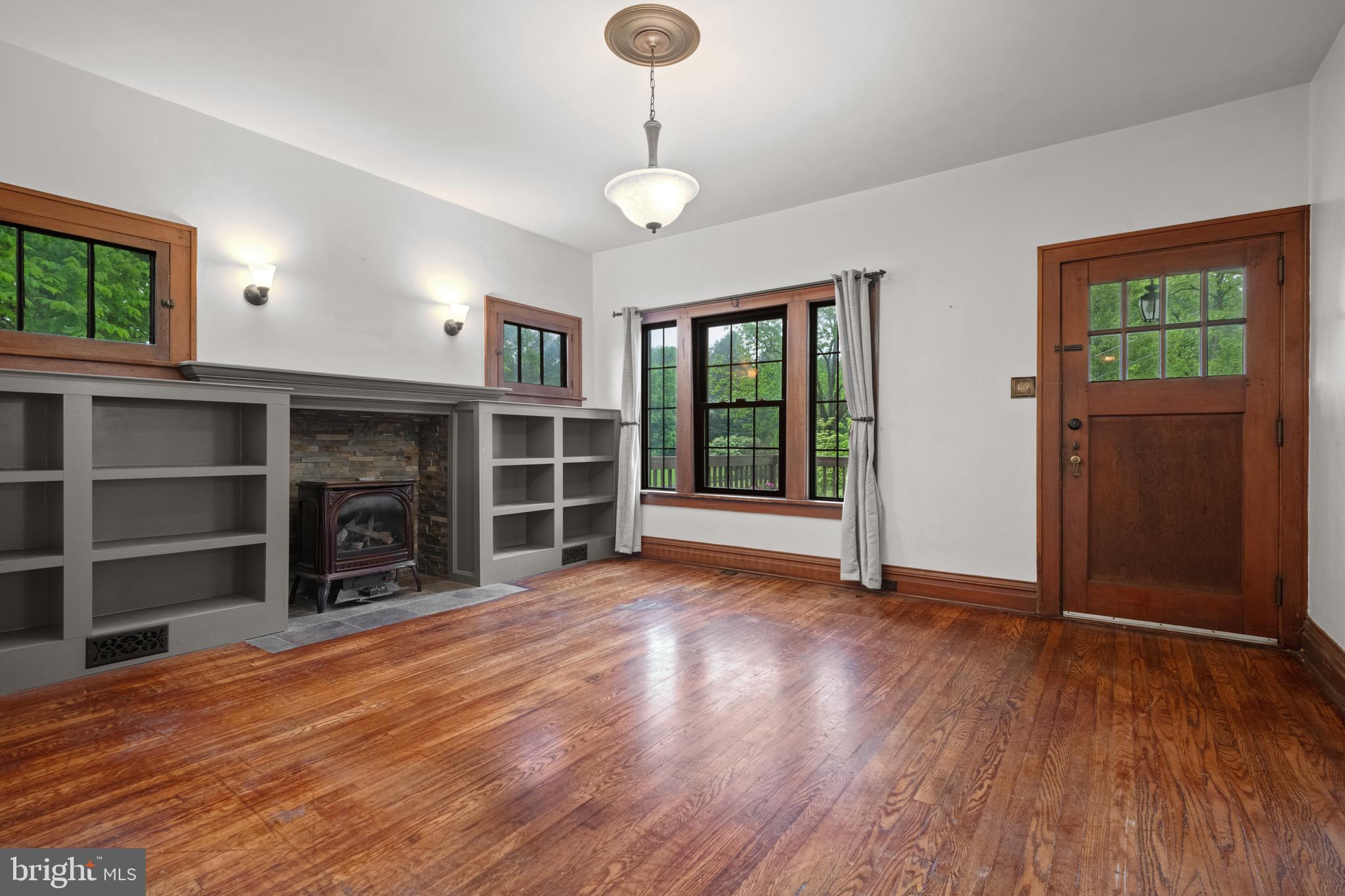 209 Ironstone Ridge Road Lancaster, PA 17603 - Photo 9 of 50 an empty room with wooden floor fireplace and windows