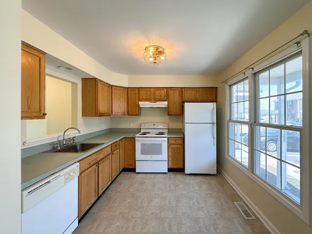 a kitchen with stainless steel appliances granite countertop a sink a stove and a refrigerator