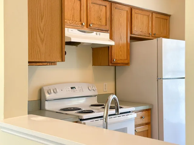 a kitchen with a refrigerator and a stove top oven