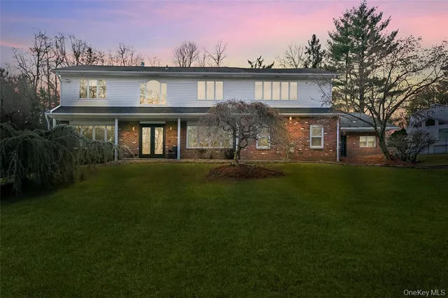 a front view of a house with a garden and yard