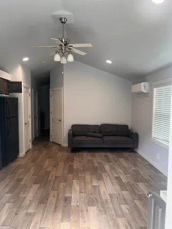 a view of a room with a ceiling fan hardwood and a window