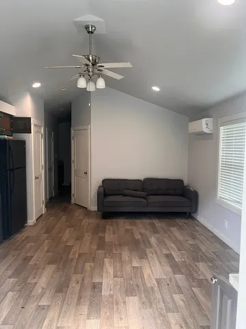 a view of a room with a ceiling fan hardwood and a window