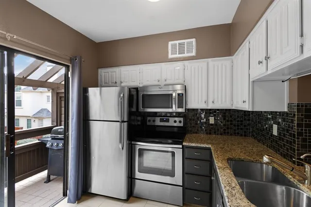 a kitchen with a refrigerator sink and cabinets