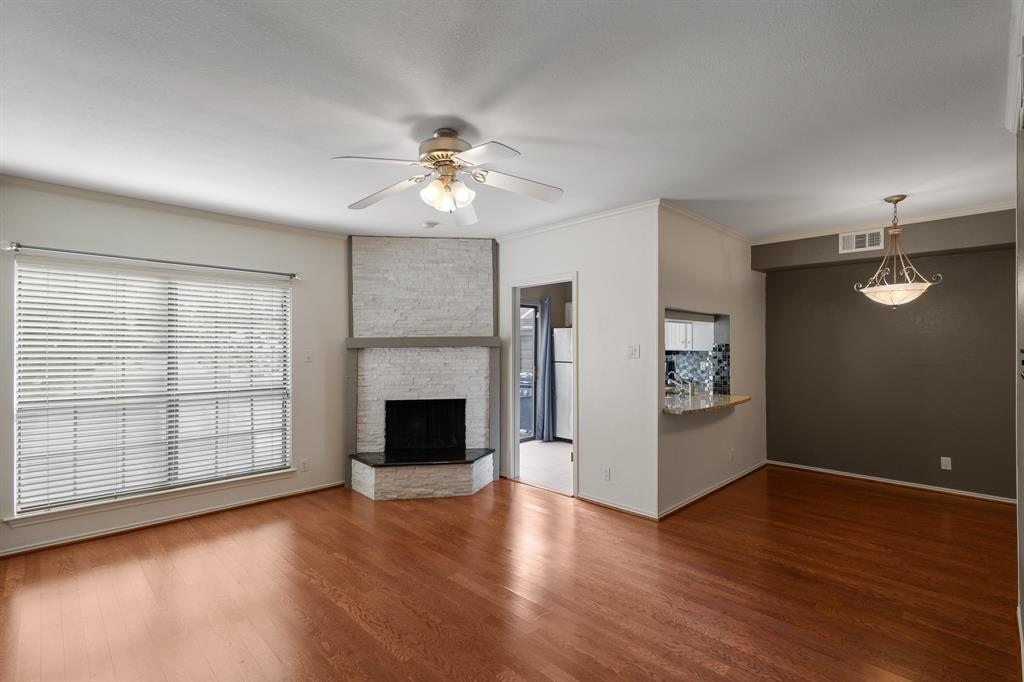 4130 Proton Drive, Unit 6D Addison, TX 75001 - Photo 14 of 38 an empty room with windows fireplace and wooden floor