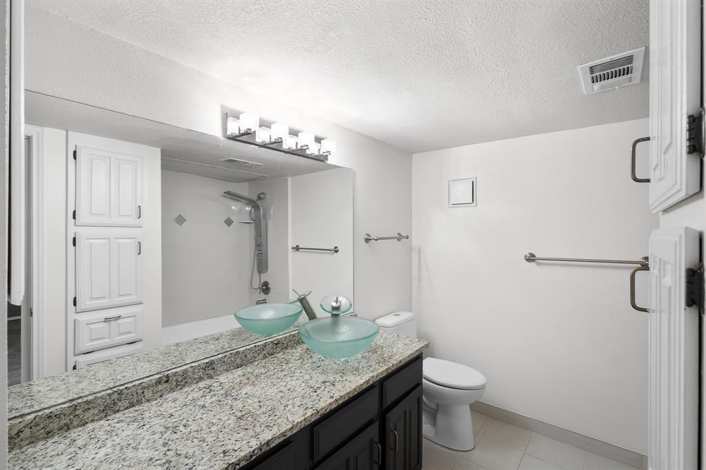 4130 Proton Drive, Unit 6D Addison, TX 75001 - Photo 20 of 38 a bathroom with a granite countertop sink a toilet and shower