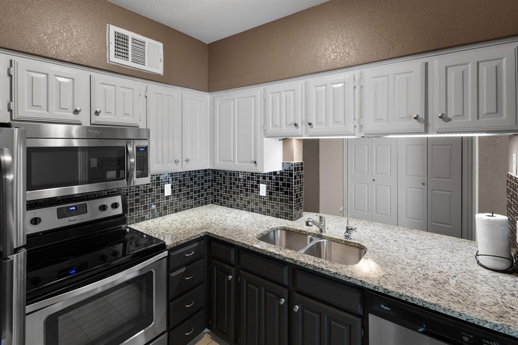 4130 Proton Drive, Unit 6D Addison, TX 75001 - Photo 25 of 38 a kitchen with granite countertop a sink dishwasher stove and cabinets with wooden floor
