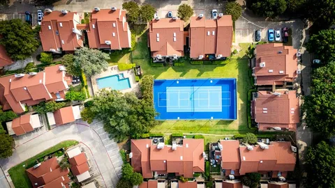an aerial view of multiple houses with yard