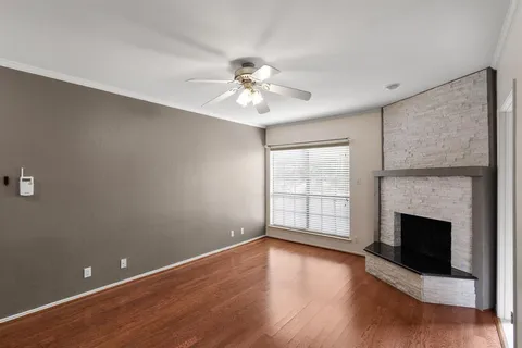 a view of empty room with wooden floor and fireplace