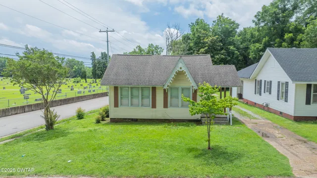 a front view of a house with a garden and plants