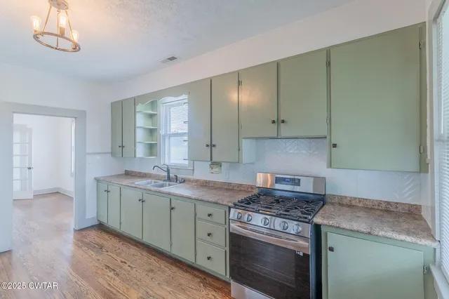 a kitchen with a sink stove and cabinets