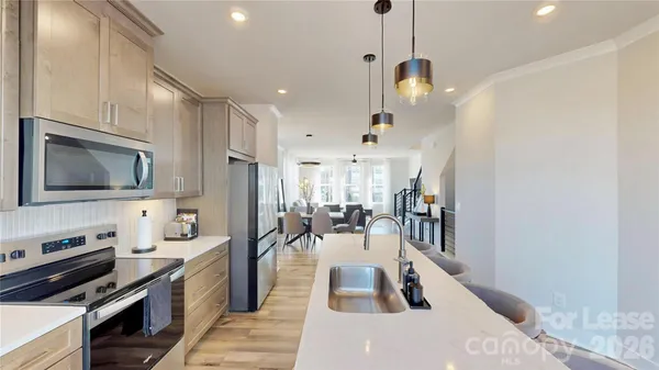 a kitchen with stainless steel appliances granite countertop a sink a stove and a refrigerator