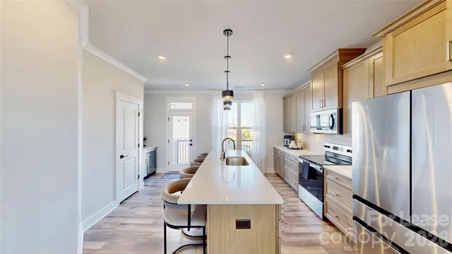 a kitchen with stainless steel appliances kitchen island granite countertop a refrigerator a stove and a sink